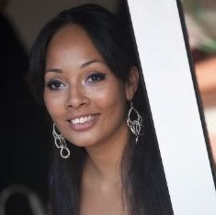 Portrait of a smiling woman with long dark hair and silver drop earrings
